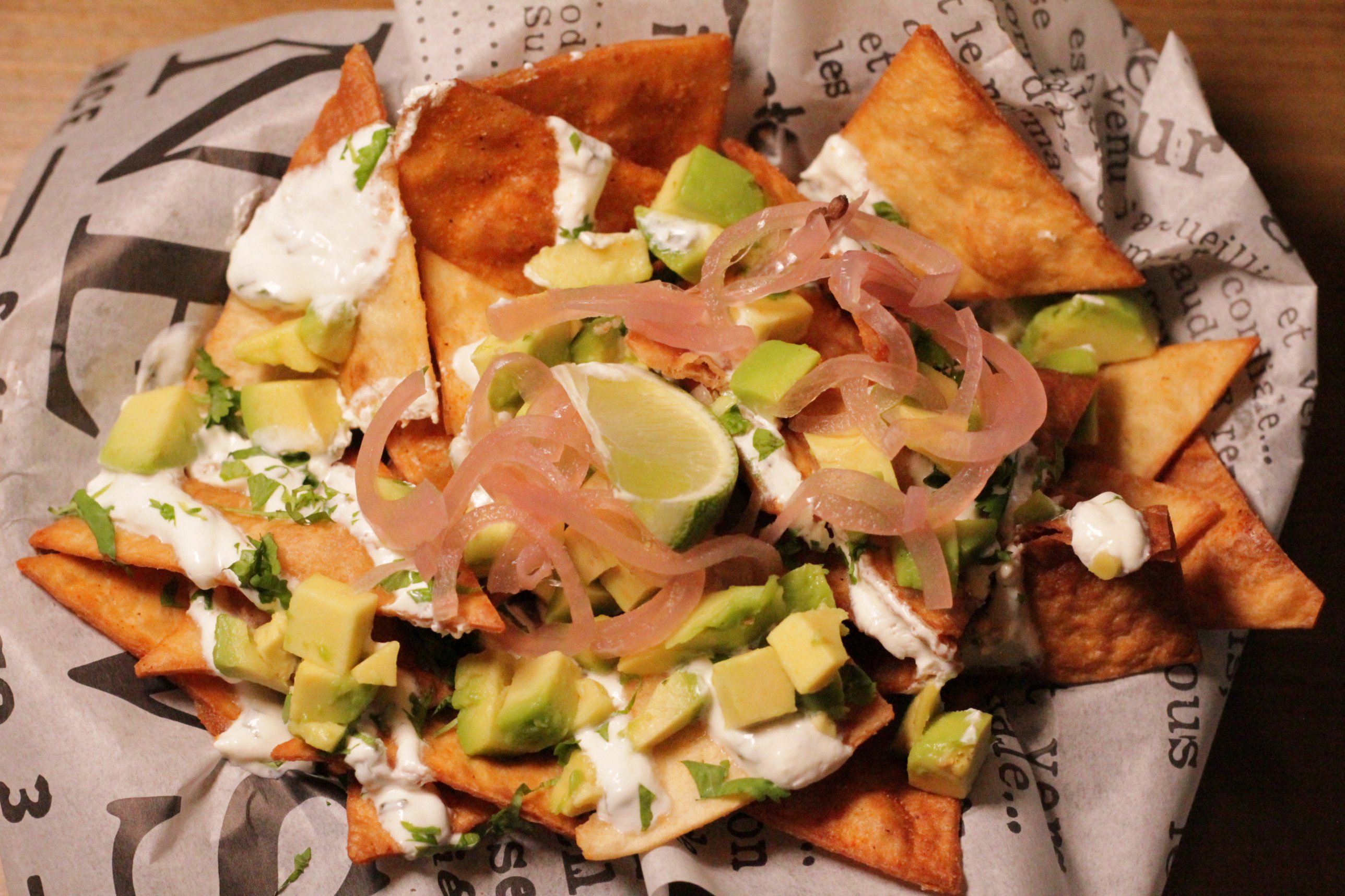 Nachos with avocado, pickled onion and lime